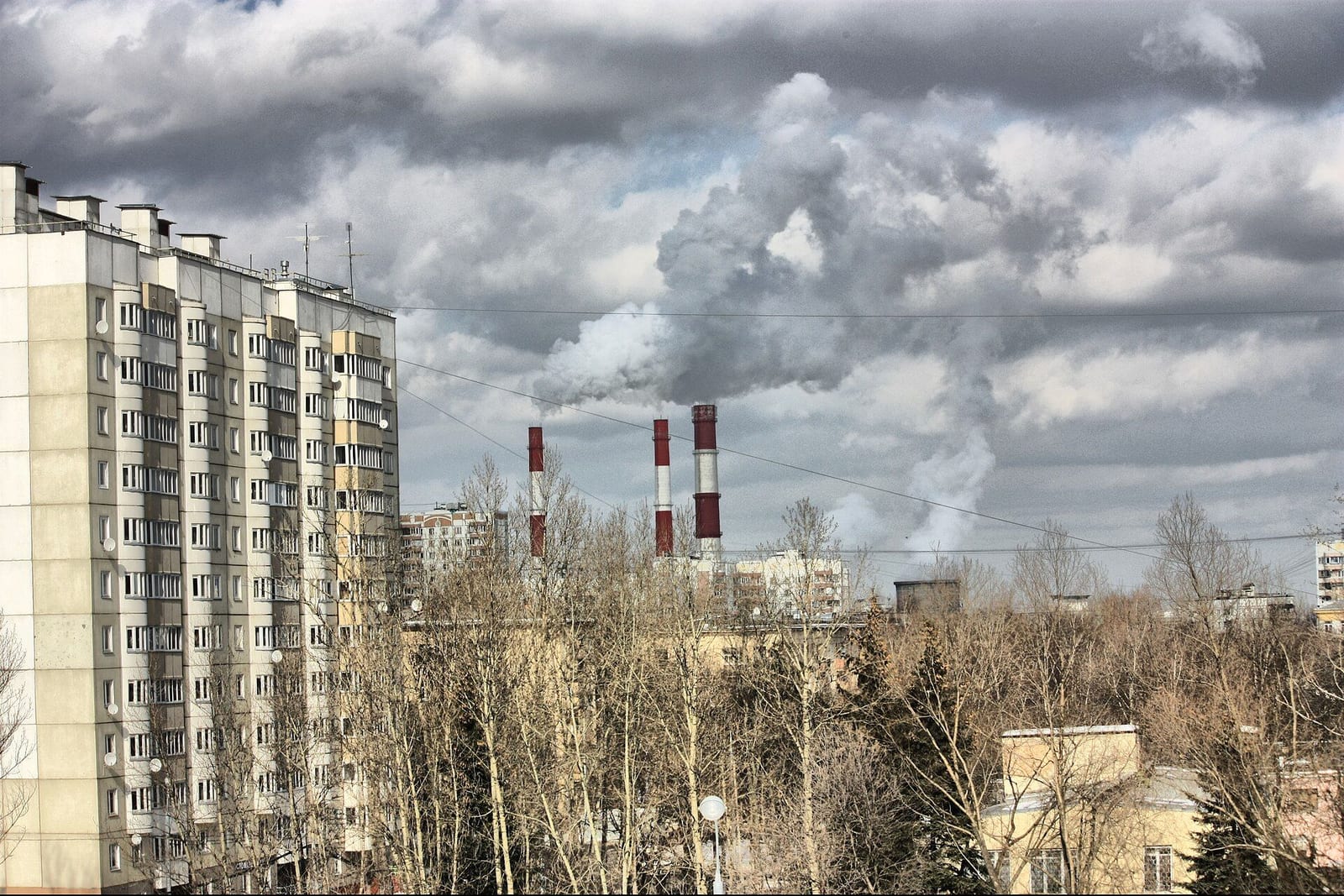 Новый дом на улице Гримау рядом с пятиэтажками, на горизонте трубы ТЭЦ-20. март 2009