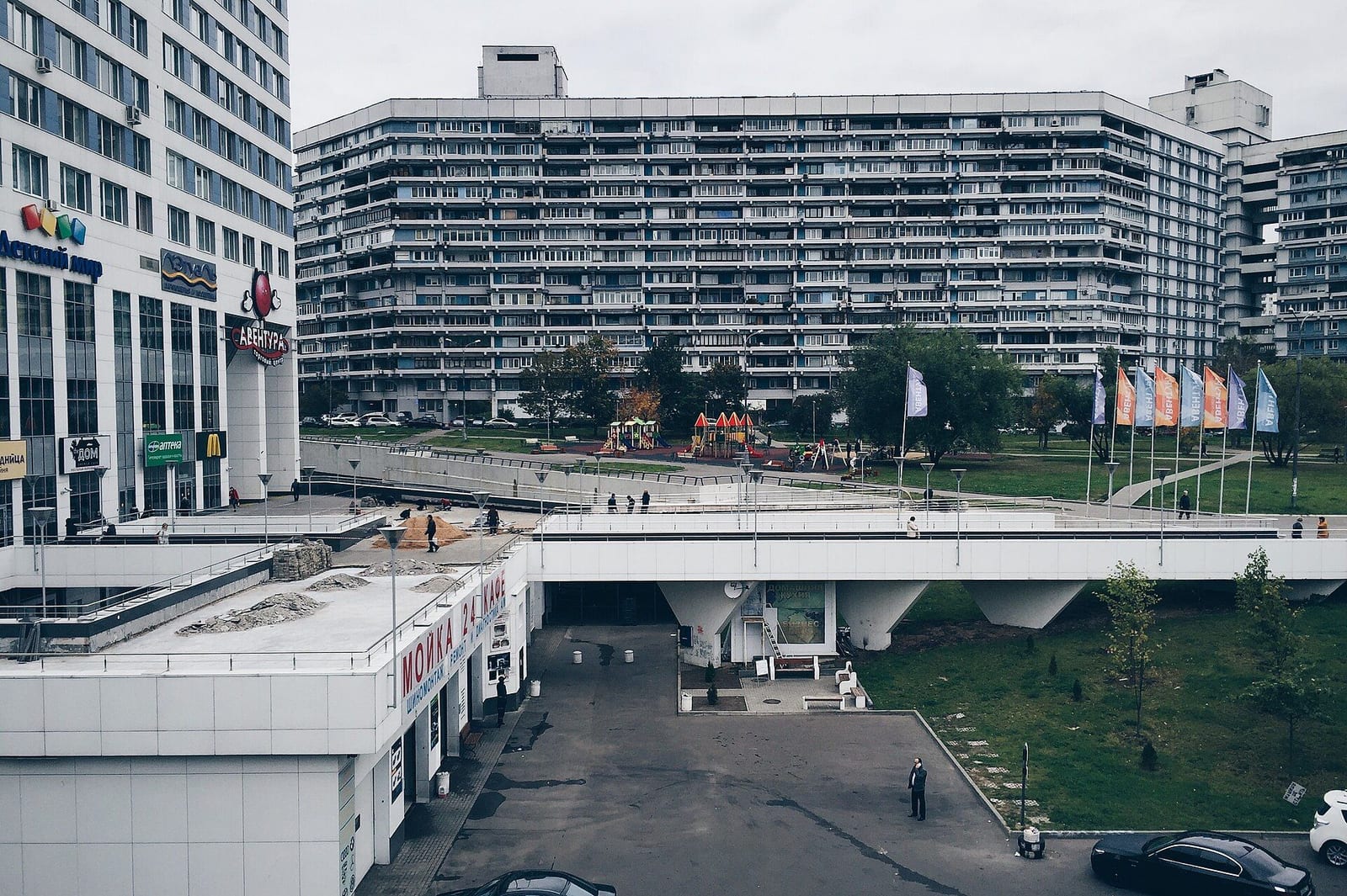 Дом 2 экспериментального района на втором плане. Впереди пешеходный мост над подземным проездом, слева торговые этажи у подножия жилой высотки. октябрь 2015