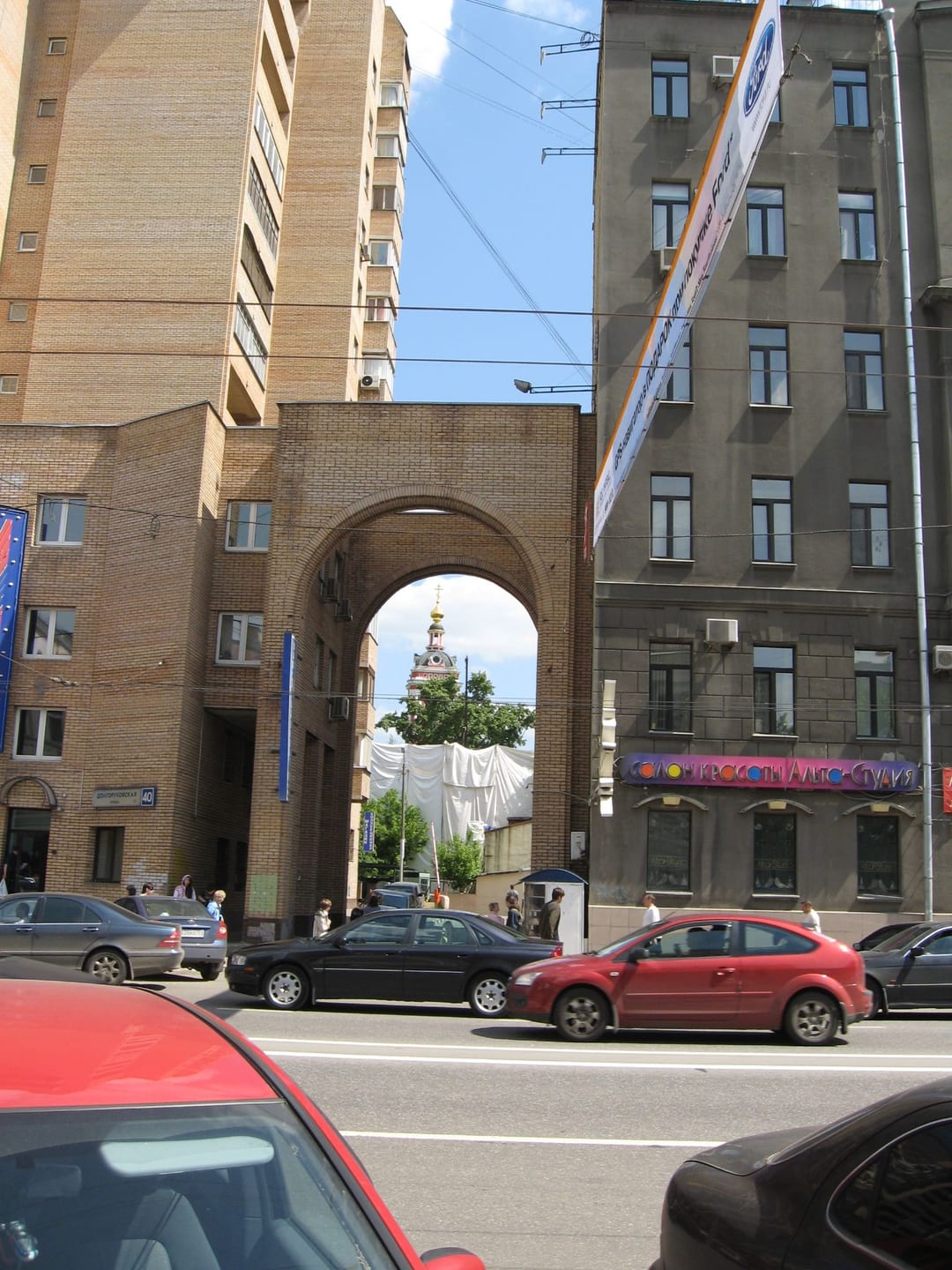 Арка между домами № 38 и 40, в её проёме колокольня церкви Пимена. Справа 12-этажный дом советских лет на углу Селезнёвской. 2015