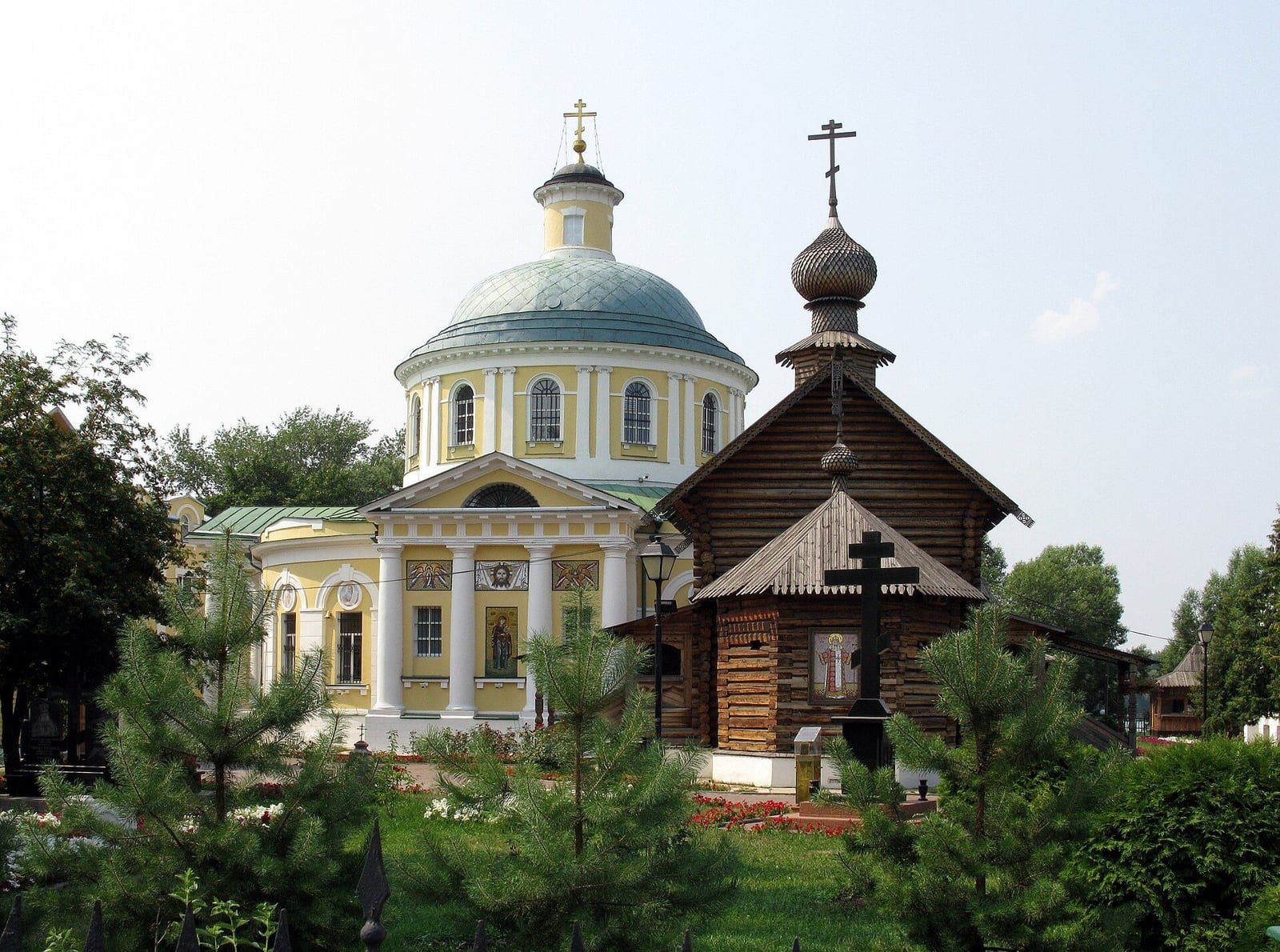 Успенский храм 1818–1823 годов и деревянный Тихоновский храм, поставленный в 1986 году на месте сгоревшей Никольской церкви. июль 2010