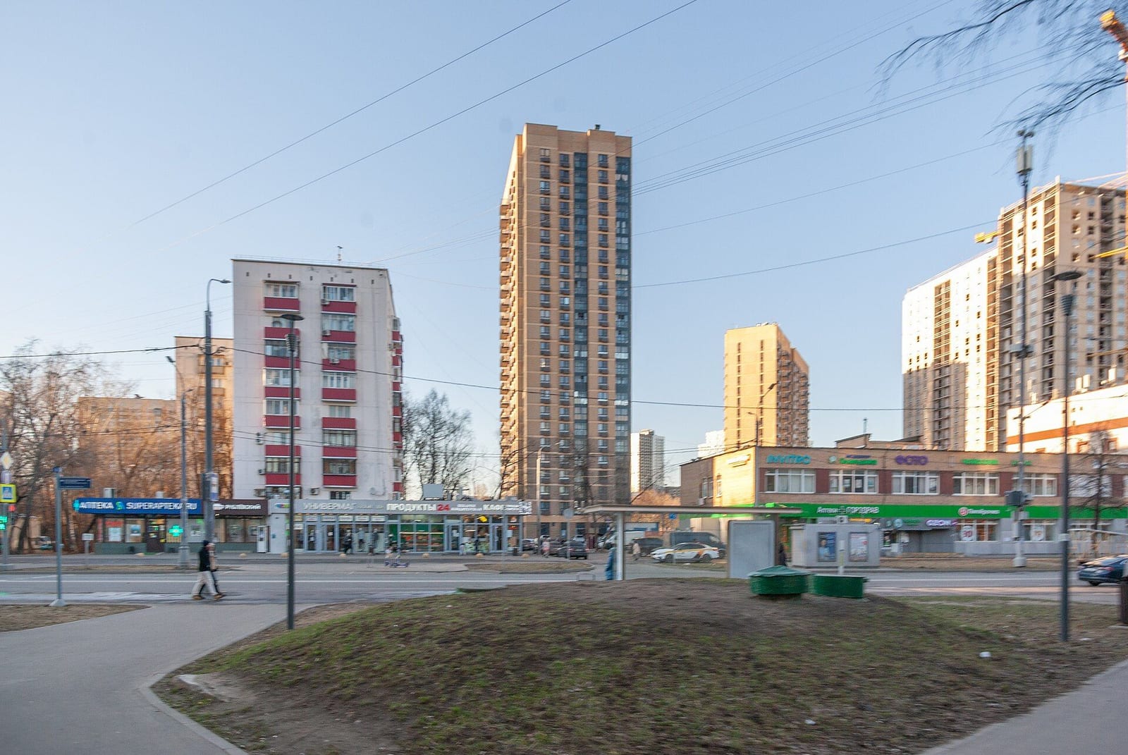 Зеленодольская улица: панельный дом советских лет и новые многоэтажки за ним. март 2025