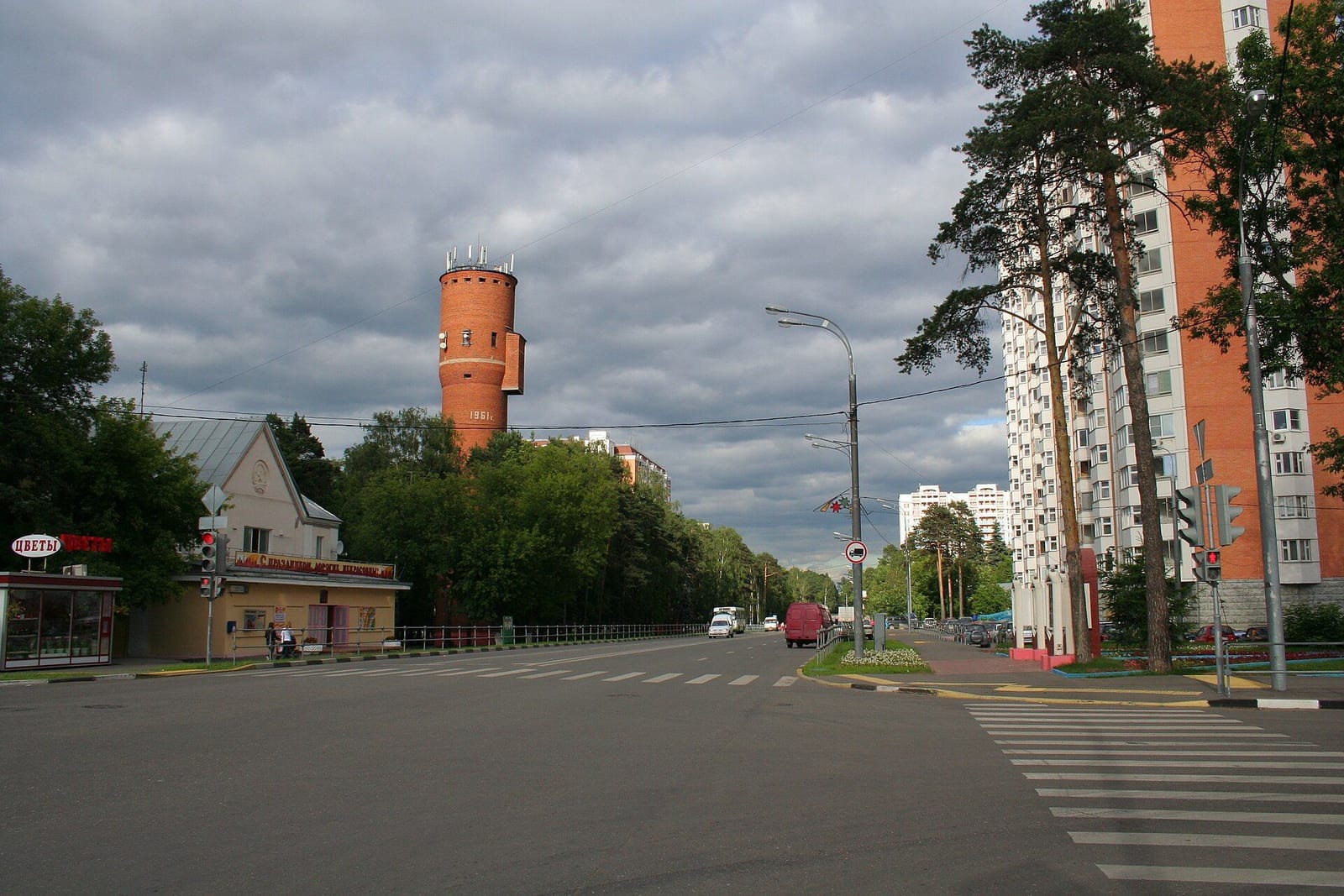 Вольская улица в старой Некрасовке. Слева кирпичная башня, которую автор снимка считает водонапорной, справа новый многоэтажный дом. июнь 2010